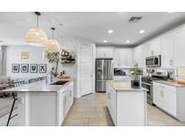 Bright, modern kitchen featuring two islands, stainless steel appliances, and granite countertops at 6338 W Raymond St, Phoenix, AZ 85043