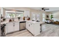 Bright kitchen features white cabinets, stainless steel appliances, quartz countertops, and a view to the living room at 828 E Le Marche Ave, Phoenix, AZ 85022
