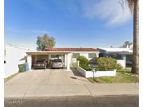 Charming single-story home featuring a classic red tile roof and convenient carport at 10408 W Devonshire Ave, Phoenix, AZ 85037