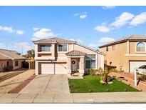 Charming two-story home featuring a well-manicured lawn and a welcoming entryway with a tiled roof at 11056 W Lane Ave, Glendale, AZ 85307