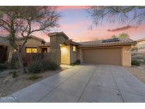 Charming home exterior with a private drive and well-maintained desert landscaping under a vivid sunset sky at 11400 E Helm Dr, Scottsdale, AZ 85255