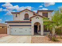 Charming two-story home featuring a white exterior, tile roof, arched entryway, and a two-car garage at 12023 W Duane Ln, Peoria, AZ 85383