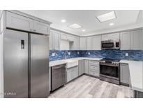 Modern kitchen featuring stainless steel appliances and stylish blue backsplash at 14224 N Newcastle Dr, Sun City, AZ 85351