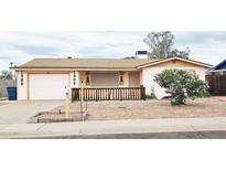 Charming single-story home featuring desert landscaping, a welcoming front porch, and an attached garage at 1586 S Lawther Dr, Apache Junction, AZ 85120