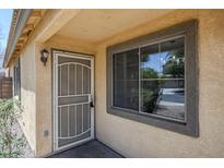 Inviting front entrance featuring a secure screen door and a window allowing natural light to brighten the doorway at 16159 W Maui Ln, Surprise, AZ 85379