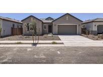Charming single-story home with a two-car garage, desert landscaping, and neutral color palette at 17557 W Victory St, Goodyear, AZ 85338