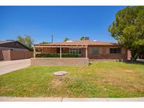 Charming brick home with a covered front porch and a well-maintained lawn at 1810 N 74Th St, Scottsdale, AZ 85257