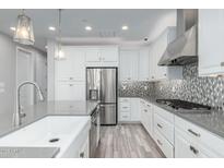 Modern kitchen featuring white cabinets, stainless steel appliances, and a stylish backsplash at 1848 S Follett Way, Gilbert, AZ 85295