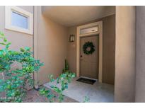 Inviting home entrance with a wreath on the door and desert plants on the side at 20100 N 78Th Pl # 1023, Scottsdale, AZ 85255