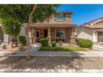 Charming two-story home featuring a covered front porch, manicured landscaping, and a welcoming facade at 2048 S Martingale Rd, Gilbert, AZ 85295