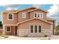 Charming two-story home featuring stone accents and a well-manicured front yard under a partly cloudy sky at 20516 S 216Th Pl, Queen Creek, AZ 85142
