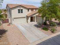 Stunning two-story home featuring a spacious driveway, three-car garage, and desert landscaping at 40232 W Marion May Ln, Maricopa, AZ 85138