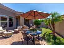 Outdoor patio featuring seating, table and chairs with umbrella, a manicured garden, and brick ground at 6202 E Mckellips Rd # 183, Mesa, AZ 85215