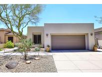 Inviting home featuring a two-car garage, neutral stucco, and desert landscaping at 6939 E Bramble Berry Ln, Scottsdale, AZ 85266