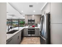 Modern kitchen with gray cabinets, stainless steel appliances, and quartz countertops, offering a sleek design at 7141 E Rancho Vista Dr # 6007, Scottsdale, AZ 85251