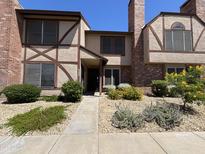 Charming townhome featuring a front yard with lush greenery and brick accents at 7905 W Thunderbird Rd # 307, Peoria, AZ 85381
