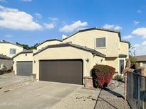 Two-story home with a brown garage door, red bushes, and a manicured yard on a sunny day at 9043 N 14Th Dr, Phoenix, AZ 85021