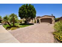Stunning home with a brick driveway, mature trees, and desert landscaping at 9842 E Celtic Dr, Scottsdale, AZ 85260