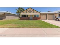 Charming single Gathering home featuring a well-maintained front yard and a two-car garage at 10201 N 97Th Ave # B, Peoria, AZ 85345