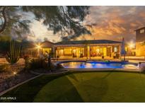 Stunning backyard with a pool, putting green, and covered patio, perfect for outdoor living and entertaining at 14426 W Becker Ln, Surprise, AZ 85379