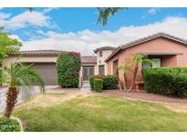 Charming single-Gathering home featuring manicured landscaping, desert flora, and a well-maintained lawn under a vibrant blue sky at 20532 W Summit Pl, Buckeye, AZ 85396