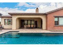 Relaxing pool view featuring covered outdoor dining and seating area, blending indoor and outdoor living spaces at 20532 W Summit Pl, Buckeye, AZ 85396