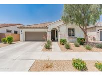 Charming single-story home featuring a well-manicured front yard with desert landscaping and a two-car garage at 24580 N 144Th Ave, Surprise, AZ 85387