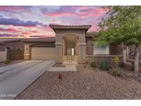 Charming single-story home featuring a desert-scape front yard and covered porch in a picturesque twilight setting at 25202 N 106Th Dr, Peoria, AZ 85383