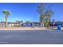Charming single-story home with a well-manicured yard, beautiful tree, and a spacious driveway at 2833 W Marlette Ave, Phoenix, AZ 85017