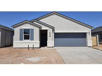 Charming single-story home featuring a gray garage door and inviting entrance with blue window shutters at 35556 N Common Ct, San Tan Valley, AZ 85140