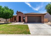 Charming single-story home with a well-maintained front yard, arched entry, and a two car garage at 40275 W Art Pl, Maricopa, AZ 85138