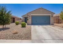 Charming single-story home with a blue garage door and low-maintenance desert landscaping at 40441 W Hillman Dr, Maricopa, AZ 85138