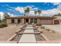 Charming home with neutral stucco, landscaped with palm trees, and a walkway leading to the front door at 4229 E Pearce Rd, Phoenix, AZ 85044