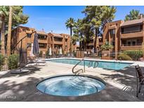 Inviting community pool and spa area with lounge chairs and shade umbrellas at 4704 E Paradise Village N Pkwy # 236, Phoenix, AZ 85032