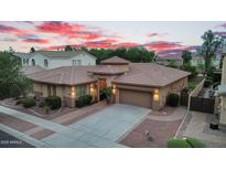 Beautiful single-story home with a well-manicured yard and a tile roof against a colorful twilight sky at 4756 E Ironhorse Rd, Gilbert, AZ 85297