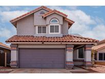 Two-story home showcasing a tiled roof and a gray two-car garage at 6853 S Roosevelt St, Tempe, AZ 85283