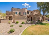 Charming home featuring stone accents, a tiled roof, a landscaped yard, and well manicured desert landscaping at 7445 E Eagle Crest Dr # 1061, Mesa, AZ 85207