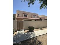 Inviting home exterior with a gated yard, desert landscaping, and a red tile roof at 8874 N 48Th Ln, Glendale, AZ 85302