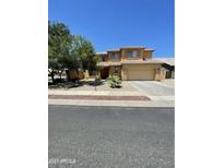 Charming two-story home with well-maintained desert landscaping, a spacious driveway, and a two-car garage at 10426 W Roanoke Ave, Avondale, AZ 85392