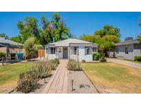 Charming home with mature landscaping, walkway, green lawn, and an inviting facade at 1110 W Heatherbrae Dr, Phoenix, AZ 85013