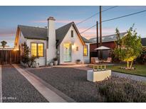 Charming white brick home featuring a lovely front patio, beautiful landscaping, and a light blue front door at 1111 E Coronado Rd, Phoenix, AZ 85006