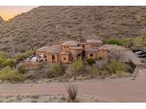 Stunning hillside home with a terracotta roof, desert landscaping, and a brick driveway at 11550 E Paradise Ln, Scottsdale, AZ 85255