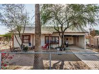 Charming single-story home with a covered front porch and mature trees at 1438 S 112Th Ave, Avondale, AZ 85323