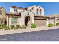 Charming two-story home with a tile roof, arched entryway, manicured bushes, and two car garage at 1952 W Yellowstone Way, Chandler, AZ 85248