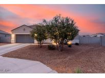 Inviting home exterior at dusk, featuring low-maintenance landscaping and a two-car garage at 203 S 190Th Ave, Buckeye, AZ 85326