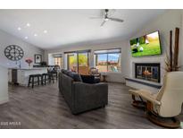 Bright living room featuring a fireplace, large windows and sleek modern furnishings at 25609 N Forest Rd # 13, Rio Verde, AZ 85263