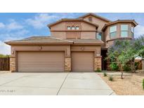 Stunning home exterior featuring a three-car garage and a well-manicured desert landscape at 26956 N 83Rd Gln, Peoria, AZ 85383