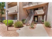 Exterior view of building showcasing a walkway and stairs to upper units and desert landscaping at 3830 E Lakewood E Pkwy # 2126, Phoenix, AZ 85048