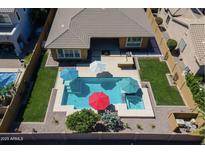 Gorgeous aerial view of a backyard featuring a sparkling pool, spa, lush landscaping, and ample patio space at 4266 E Blue Sage Ct, Gilbert, AZ 85297