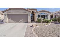 Inviting single-story home features a two-car garage and low maintenance desert landscaping in front at 43727 W Wade Dr, Maricopa, AZ 85138